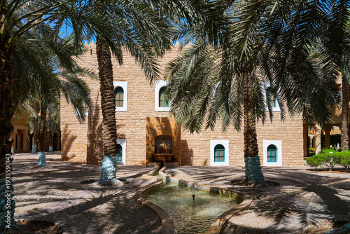 Foto Traditional water fountain and palm grove at the historic Murabba Palace of Riya