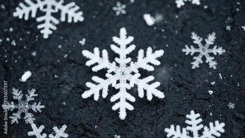 Close-up of intricate snowflakes against a dark, textured background.