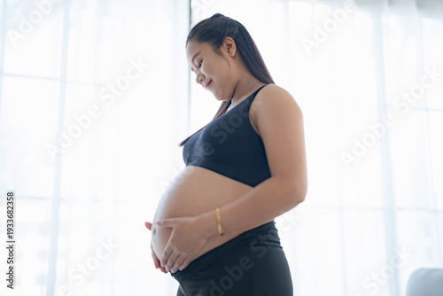 Pregnant asian woman holds hands on belly touching her baby caring about her health Beautiful happy pregnant woman tender mood photo of pregnancy. Free Download Pregnant asian woman holds hands on belly touching her baby caring about her health Beautiful happy pregnant woman tender mood photo of pregnancy. - GFXLoad