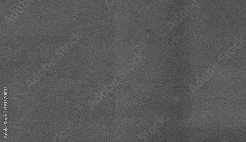 Close-up textured grey paper background with subtle grain and slight shadow.