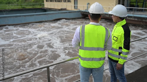 Professional environmental engineers inspecting a modern wastewater treatment plant process, monitoring water quality and aeration system for industrial sustainability and ecology.