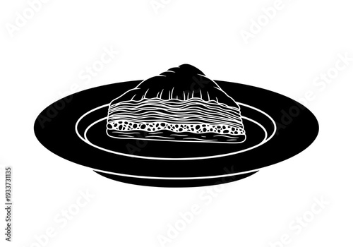 Layered dessert on a black plate viewed from above a circular serving dish isolated