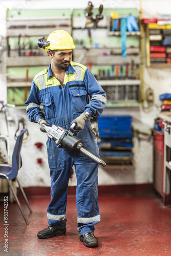 Close portrait of a marine engineer in protective clothing working in an industrial maritime environment.