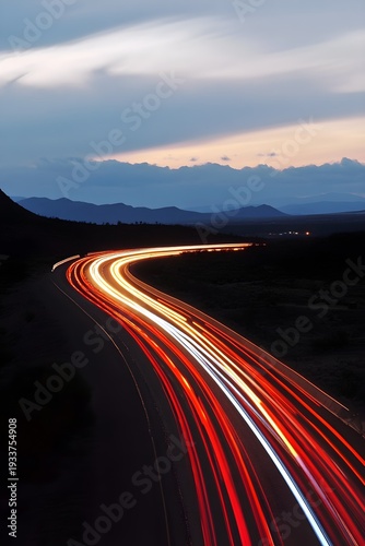 Long exposure highway light trails at dusk with mountain silhouette