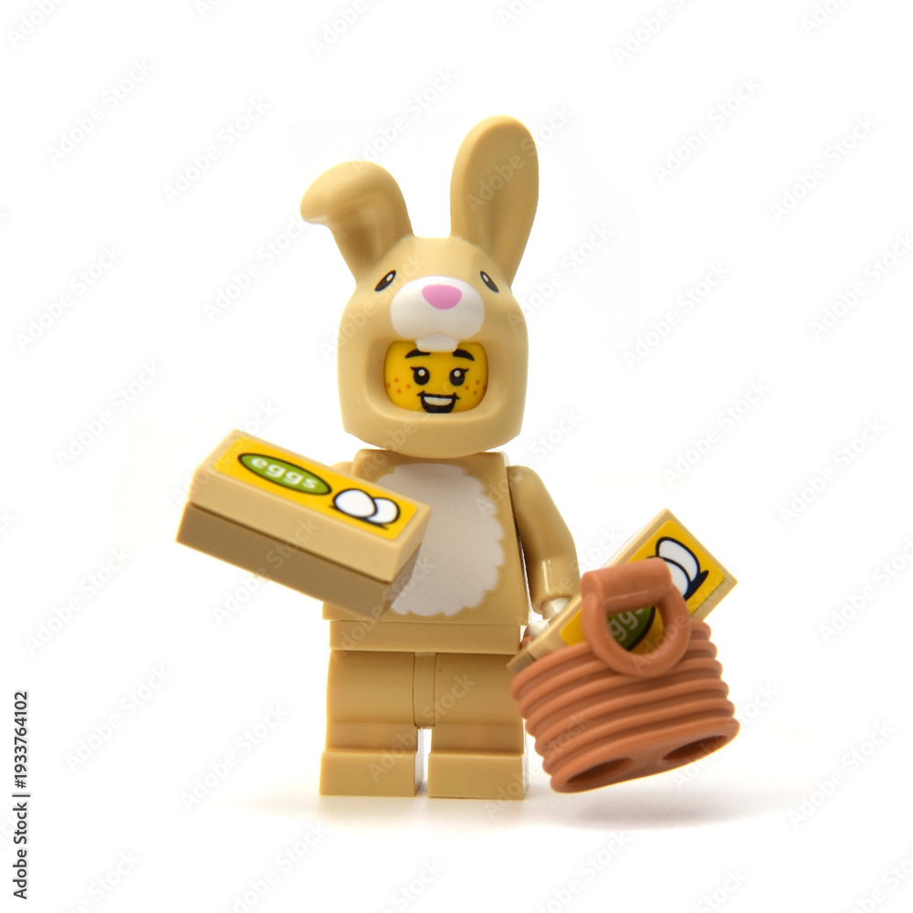 Obraz premium Lego minifigure of happy bunny is hunting easter eggs isolated on white. Editorial illustrative image of Easter holiday by popular plastic bricks constructor.