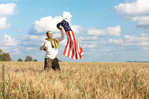 Man waving American flag standing in grass farm agricultural field , holidays, patriotism, pride, freedom, political parties, immigrant