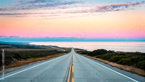 Road stretches along the coast at sunset with calm waters and colorful sky in the background