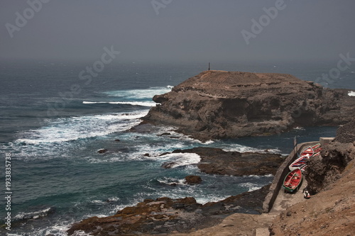 The rugged Atlantic coast of Cape Verde with colorful wooden boats on the shore