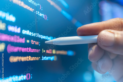 Software developers are examining computer code, which represents the concept of advanced technological information for building network security platforms.