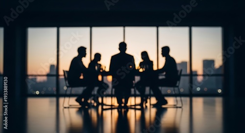 Silhouettes of people in a meeting around a table with city skyline at sunset business teamwork