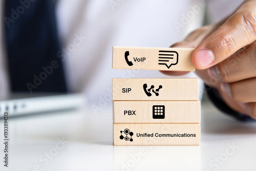 Businessman stacking wooden blocks with communication icons representing VoIP SIP PBX and Unified Communications business strategy