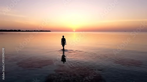 Solitary Figure Walking Towards Sunset Over Calm Ocean Waters