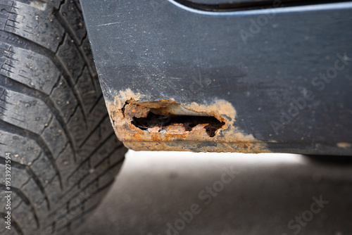 Fotografie Rusted car rocker panel with corrosion hole