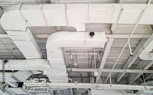 Modern Industrial Ceiling with Exposed White HVAC Ducts, Pipes, and Lighting Fixtures for Commercial Spaces