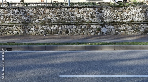 Wallpaper Mural Boundary stone wall with sidewalk and shaded street in front. Background for copy space. Torontodigital.ca