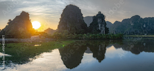 Картината върху платно Sunrise over majestic karst mountains and tranquil rice paddies in Tam Coc, Ninh Binh, Vietnam