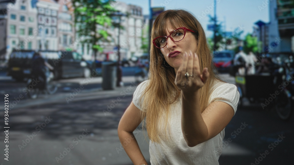 Fototapeta premium Woman beckoning with hand and pointing finger on a city street wearing red glasses; defiance challenge.