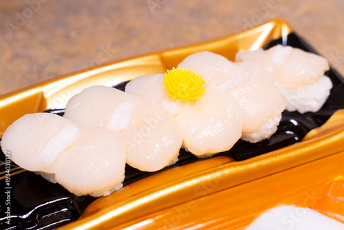 Fresh scallop sushi is neatly arranged on a serving tray.