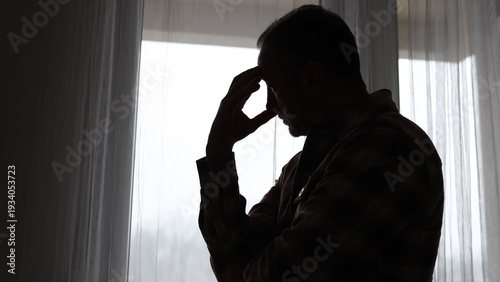 Man with headache, depression, sadness and loneliness at home