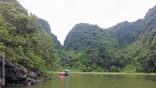 Asia , Vietnam , Trang An  03,04,2026 Thuy Dinh Pagoda emerges from the water - UNESCO World Heritage - Traditional boats carry tourists on the river - tourist attraction  sightseeing close to Ninh Bi