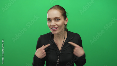 Photos Young caucasian woman trainer points finger to chest with whistle around neck in studio; surprise innocence