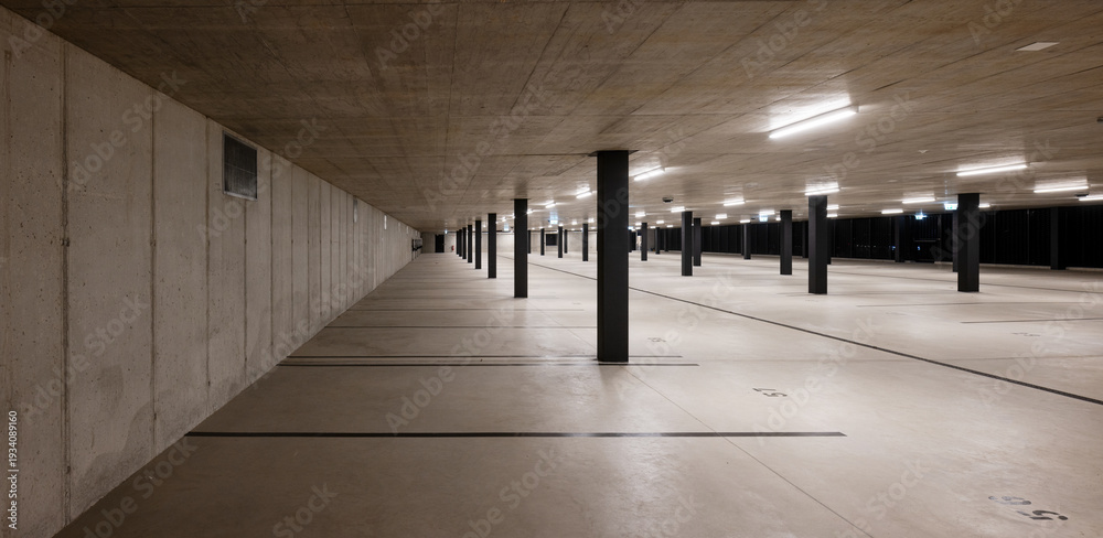 Fototapeta premium Front view of a new light-colored public parking lot with black stripes and columns. Nobody inside