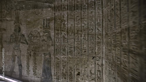 Dendera temple interior sanctuary with illuminated hieroglyphic walls and ritual reliefs in Egypt, ancient sacred chamber with dramatic lighting on carved sandstone surfaces.