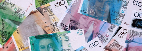 Wallpaper Mural Gibraltar pound money bills pile on table. Gibraltar banknotes of GIP currency close up. Torontodigital.ca