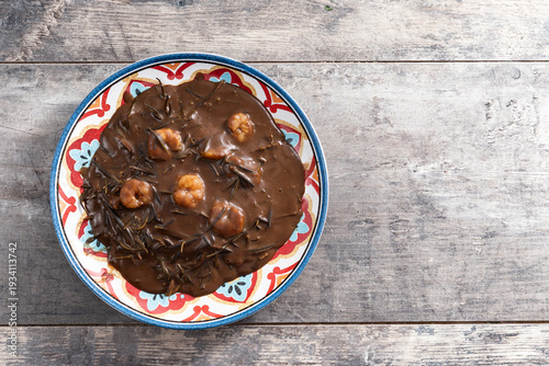 Mexican romeritos with mole sauce and shrimp on wooden table. Top view. Copy space
