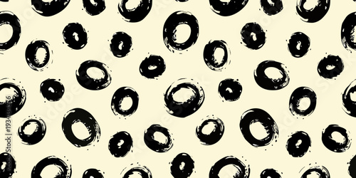 Abstract pattern of black brushstroke circles on a pale beige background
