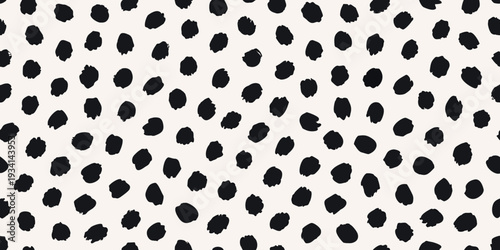 Abstract black spots scattered across a cream colored background
