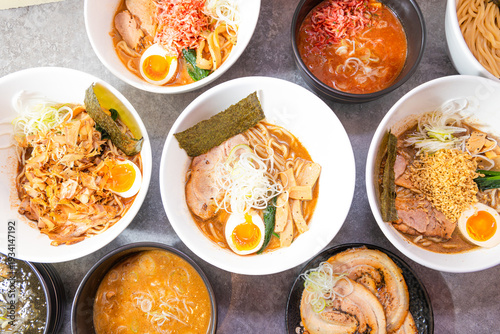 Fotografía Several ramen bowls fill the frame, each with noodles, chashu, soft eggs, seaweed and varied broths