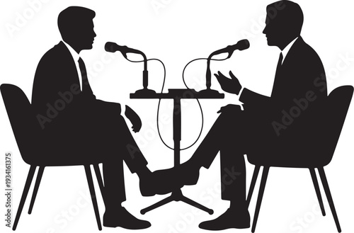 Two men in suits sitting at a table with microphones