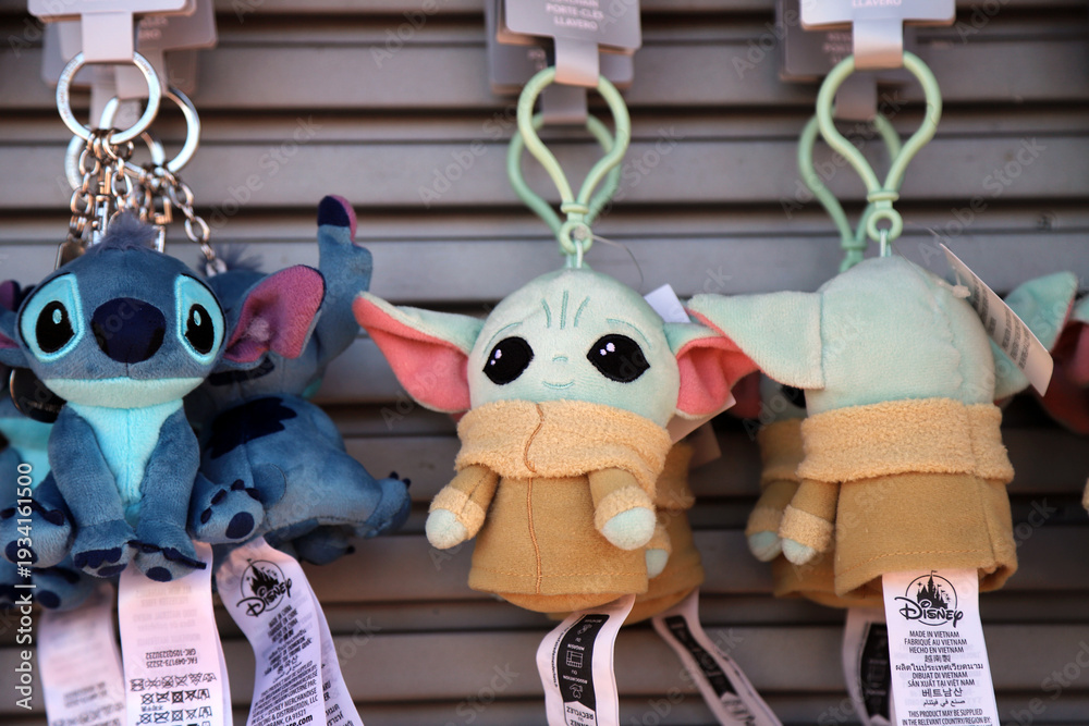 Naklejka premium Grogu and Stitch plush keychains displayed for sale in retail store