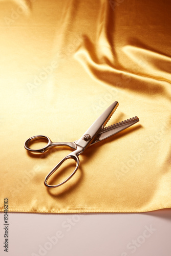 Tailor’s Scissors on Golden Satin Fabric