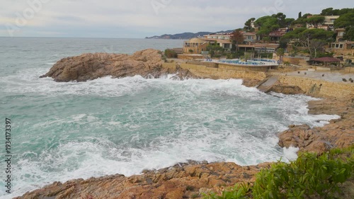 Rough sea waves crashing on rocky coastline