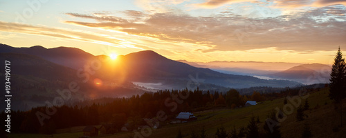 Photos Sun rises over rolling hills, casting warm golden glow across landscape