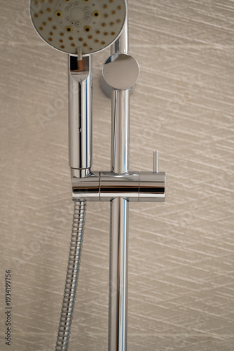 Konstfotografi Handheld showering system with chrome finish and flexible hose on a modern bathr