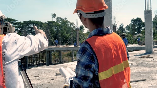 Engineer and surveyor worker working with theodolite transit equipment at outdoors construction site. 4K