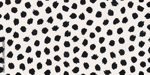 Abstract black spots scattered across a cream colored background texture