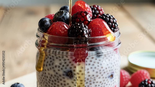 Jar of mixed berries with syrup on wooden surface