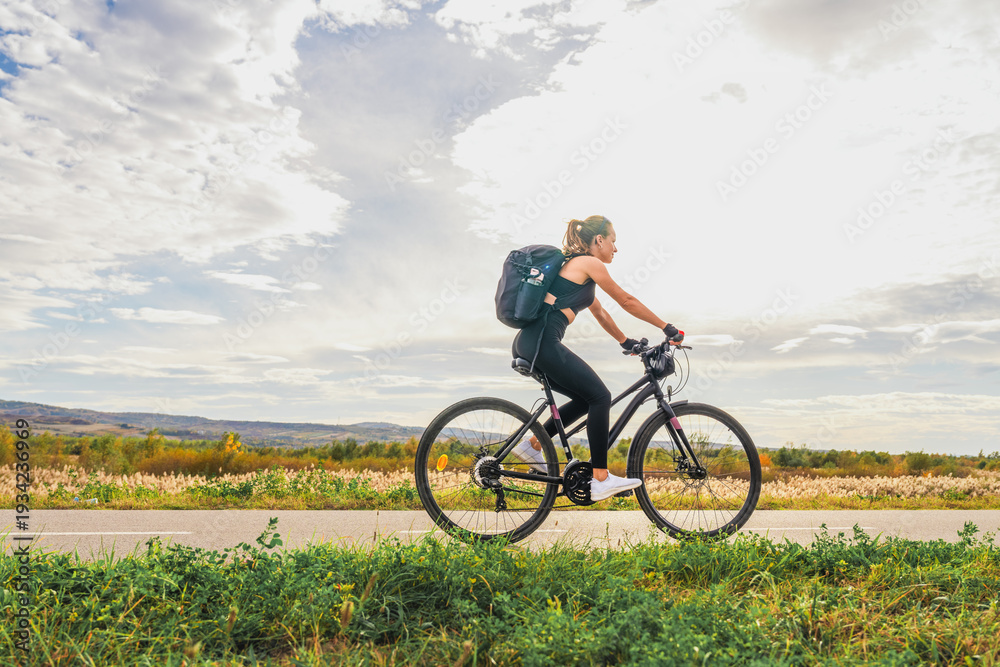 Fototapeta premium Weekend getaway concept with woman biking outdoors