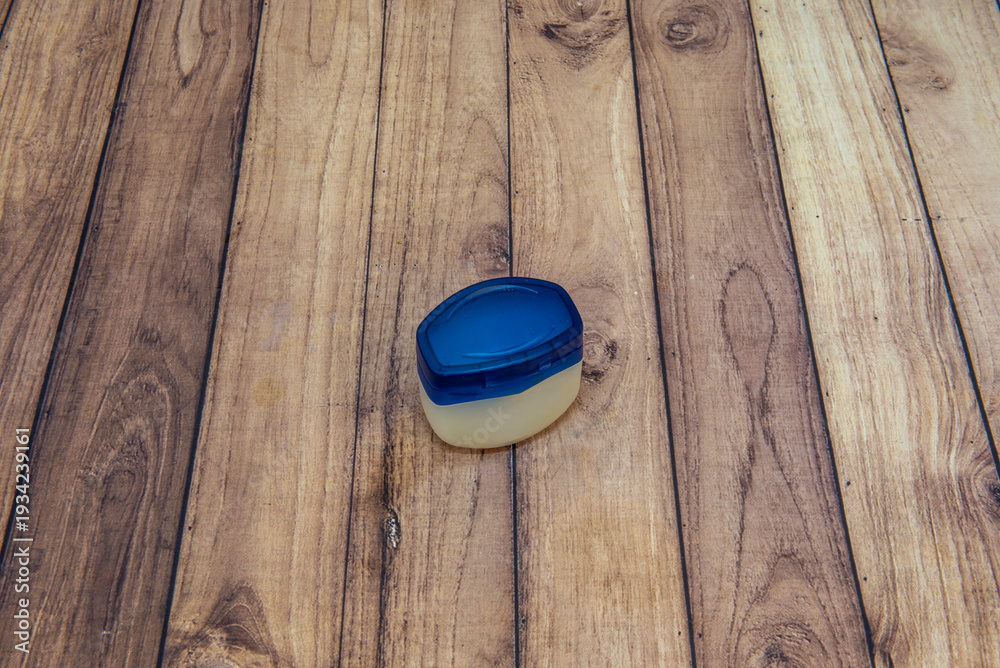 Fototapeta premium A plastic jar full of moisturizing cream on a wooden table