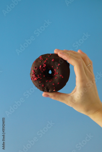 human hand holding a donut