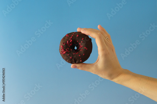 hand holding a chocolate donut