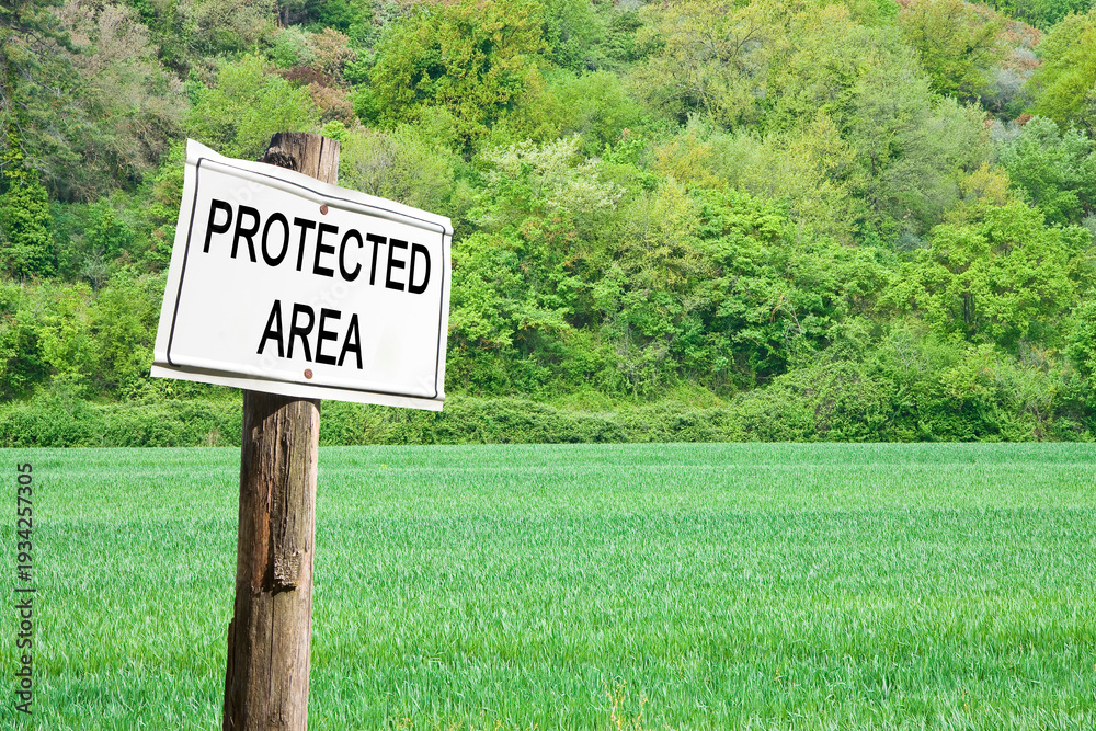 Obraz premium Protected area written on a field sign - Sign indicating in the countryside - image with copy space