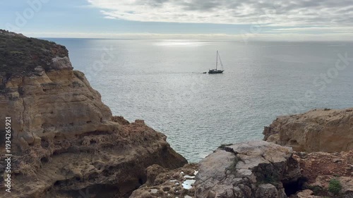 Boats visiting stunning cove with clear blue sea and golden cliffs Portuguese coast Lagos Portugal