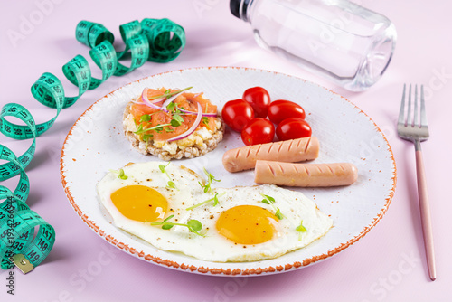 Fried eggs with sausage, cherry tomatoes and buckwheat bread with salmon fish