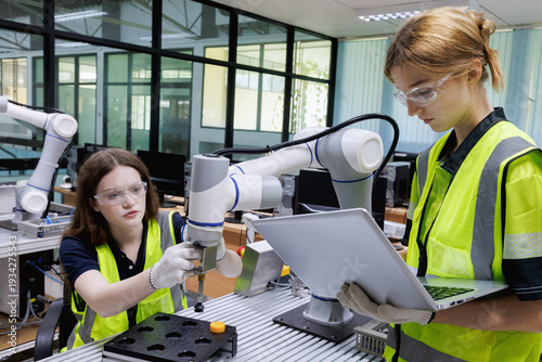 automation machine engineer woman students study and inspection control robot arm machine in robotics engineering academy at university or factory workshop. AI robot technology,