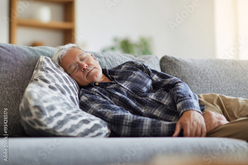elderly man napping on sofa in bright room, casual relaxed posture, serene and calm.
